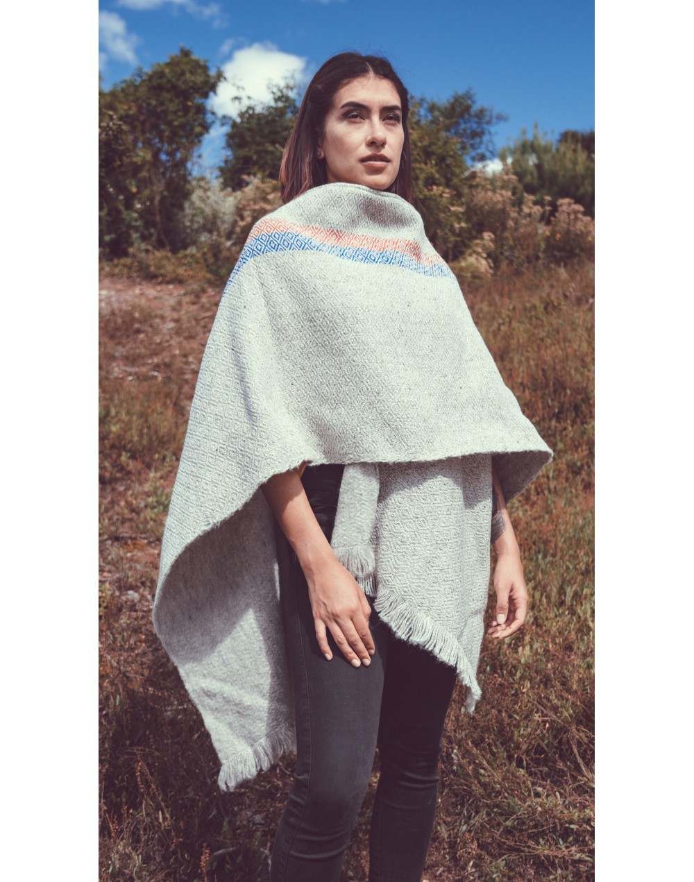 Capa ruana gris clara con franja vertical rombos